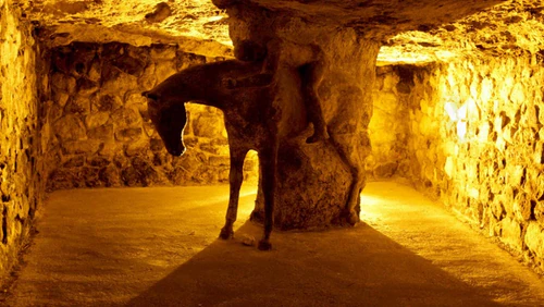 Budapeşte Kalesi Tepesi’nin altında saklı olan Labirent, şehrin mağaraları, jeolojisi ve efsanelerini sergileyen oyulmuş bir yeraltı karmaşasıdır. Mum ışığında koridorlarda gezerken jeolojik oluşumları, antik buluntuları ve Budapeşte’nin tortul geçmişi ile ortaçağ hikayelerini takip eden çoklu multimedya sergilerini görürsünüz. Yollar kemerli odalar arasında örülür; dramatik aydınlatma ve ara sıra gelen ses efektleri keşif duygusunu artırır. Ziyaret, serin bir kaçış ile kültürü, tarihsel bağlamı ve Tuna Nehri’ne bakan yükseltilmiş geçitlerden panoramik manzaraları bir araya getirir." — Müze, rated 3.8/5