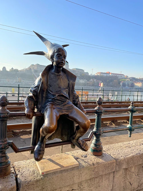 Budapeşte’deki Küçük Prenses Heykeli, tarihi şehrin sessiz bir köşesine saklanmış sevimli, küçük bir bronz heykeldir. Ölçeği küçük olsa da karakteri büyük olan bu heykel, akıcı bir elbise giymiş genç bir kızı tasvir eder ve meraklı geçicilerin daha yakından bakması ve kısa bir fotoğraf çekmesi için çağrıda bulunur. Aileler ve gezen fotoğrafçılar için keyifli bir deneyim sunar; taşlı sokaklar ve yakınlardaki kafeler boyunca keyifli bir duraklama ile Budapeşte gezintinize tatlı bir ayrıntı katacaktır. Sıcak, neşeli bir hava bekleyin; kısa, akılda kalıcı bir sapma için ideal., rated 4.6/5